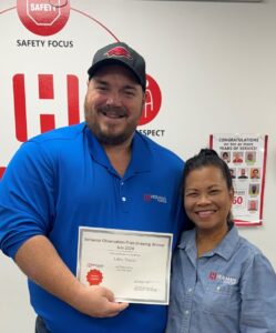 July 2nd place winner Libby Nixon stands next to her supervisor, Brad Wyles as he displays her certificate.